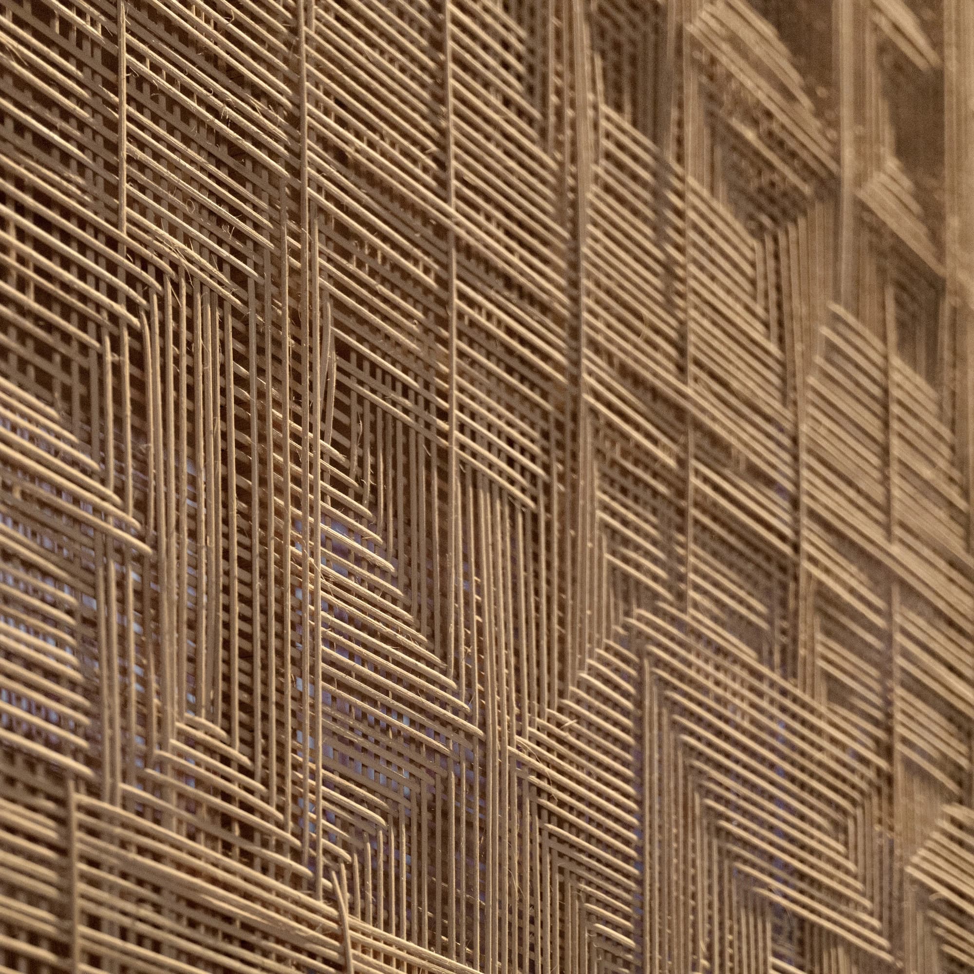 Close-up of natural rattan weaving for Matter and Place, showing an intricate layered geometric pattern.